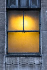 Wall Mural - warmly lit window on urban building