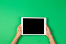 Child Hands Holding Tablet Computer On Light Green Background