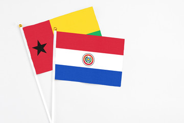 Paraguay and Guinea Bissau stick flags on white background. High quality fabric, miniature national flag. Peaceful global concept.White floor for copy space.