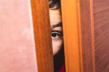 Boy Peeking Behind A Door