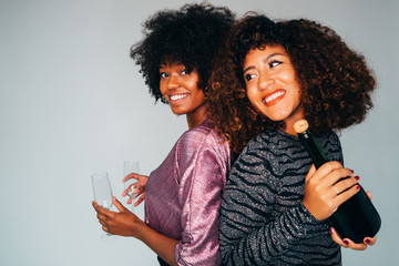 Portrait of a Black American African women with a glass of champagne. Celebrating and smiling.