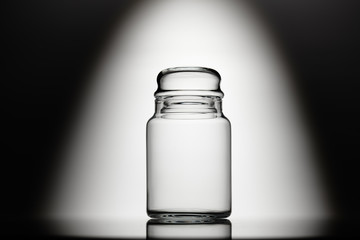 Empty glass jar on a black and white background