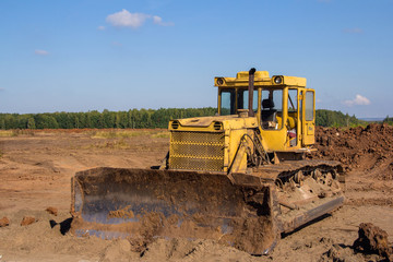 An old industrial bulldozer is parked at a construction site.