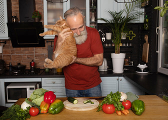 Bearded senior Man preparing healthy and tasty salad in kitchen.