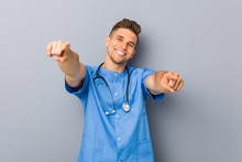 Young Nurse Man Cheerful Smiles Pointing To Front.