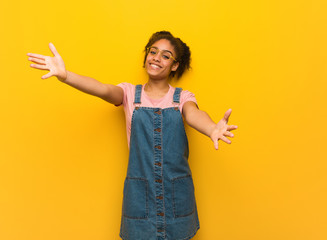 Wall Mural - Young black african american girl with blue eyes inviting to come