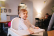 © Aleksandr - Portrait of adorable little girl on highchair. Baby laughing and play. Happy girl smile