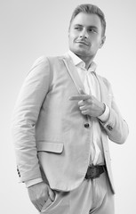 Handsome blonde man model in a fashion gray suit in studio