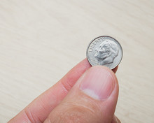 Photograph Of A Man Holding An American Dollar Dime.