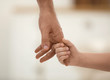 © New Africa - Father holding hands with his child indoors, closeup. Happy family