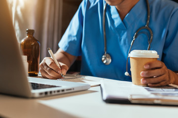 Wall Mural - Medical technology concept. Doctor working with mobile phone and stethoscope and digital tablet laptop in modern office at hospital in morning light