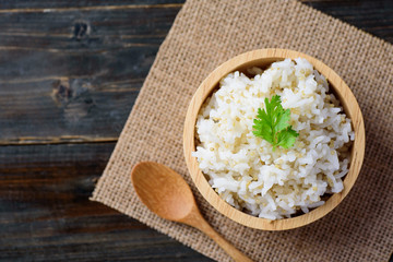 Cooked rice with quinoa seed in bowl on wooden background, top view