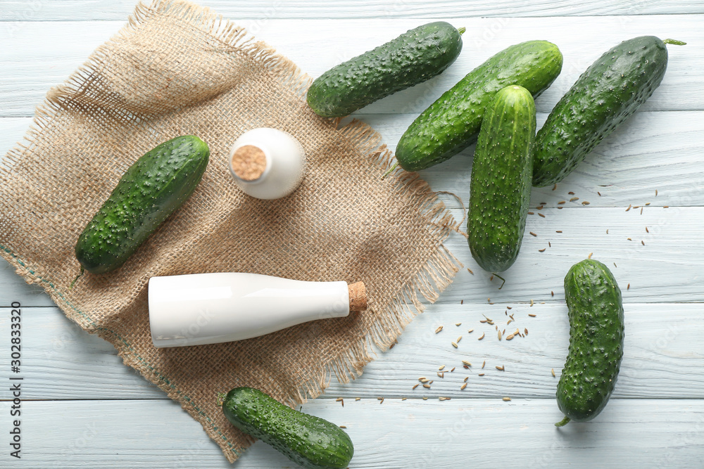 Fresh cucumbers with oil and spices on table