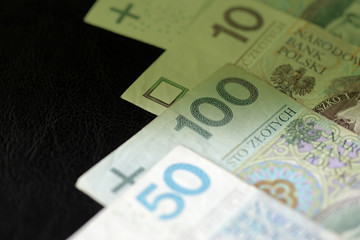 Wall Mural - Polish zloty banknotes on a dark surface close-up. Money background green color toned