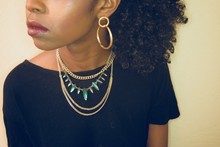 African American Women Wearing Gold And Green Necklace