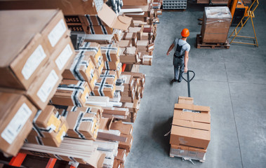 Top view of male worker in warehouse with pallet truck