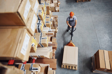 Top view of male worker in warehouse with pallet truck