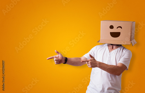 Fotografía Funny man wearing cardboard box on his head with smiley face