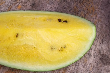 A slice of delicious, juicy sweet, fresh, yellow watermelon on a wooden table.