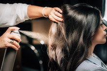 Hairstylist Spraying Woman’s Hair