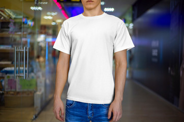 Wall Mural - Front view of a white t-shirt mockup design on a young guy.
