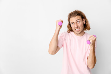 Sticker - Portrait of funny man with dumbbells on light background