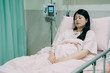 © PR Image Factory - Image of sick asian japanese young woman with nasal cannula sitting in bed and fell asleep in midnight. unconscious female patient lying and sleeping with nose tube in hospital room. illness concept.