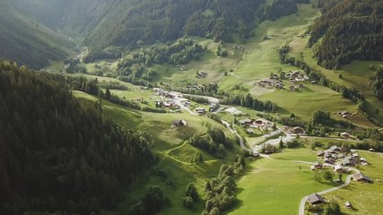 Wall Mural - Aerial tracking shot of village in a mountain valley in France