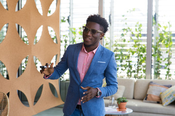 Excited speaker telling audience about project. Stylish African American business man holding marker, speaking and gesturing. Startup leader concept