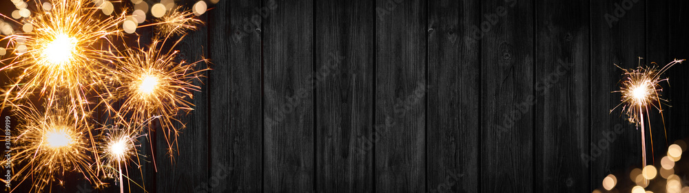 Silvester party New year background banner panorama long- sparklers and bokeh lights on rustic wooden texture, with space for text - obrazy, fototapety, plakaty 