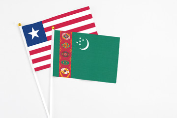 Turkmenistan and Liberia stick flags on white background. High quality fabric, miniature national flag. Peaceful global concept.White floor for copy space.