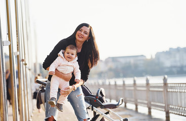 Wall Mural - Mother with pram in casual clothes with her child is in the park