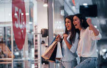Feeling Excited. Two Young Women Have A Shopping Day Together In The Supermarket