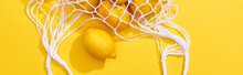Top View Of Fresh Ripe Whole Lemons In Eco String Bag On Yellow Background, Panoramic Shot