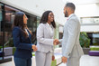 © Mangostar - Happy diverse business partners greeting each other. Business man and women standing in office hall, shaking hands, talking, smiling. Partners meeting concept