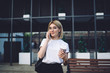 © BullRun - Blond woman talking on phone on street