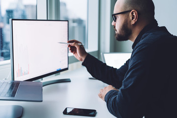 man looking at graph on computer