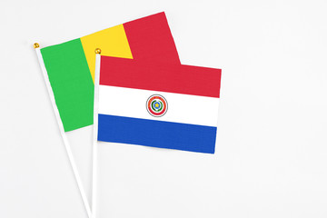 Paraguay and Mali stick flags on white background. High quality fabric, miniature national flag. Peaceful global concept.White floor for copy space.