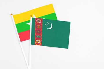 Turkmenistan and Myanmar stick flags on white background. High quality fabric, miniature national flag. Peaceful global concept.White floor for copy space.