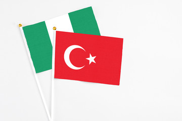 Wall Mural - Turkey and Nigeria stick flags on white background. High quality fabric, miniature national flag. Peaceful global concept.White floor for copy space.