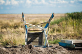 Fototapeta Na sufit - Old inverted wooden chair on the grass. Abandoned terrain