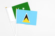 © sezerozger - Saint Lucia and Pakistan stick flags on white background. High quality fabric, miniature national flag. Peaceful global concept.White floor for copy space.
