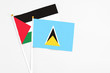 © sezerozger - Saint Lucia and Palestine stick flags on white background. High quality fabric, miniature national flag. Peaceful global concept.White floor for copy space.