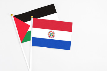 Paraguay and Palestine stick flags on white background. High quality fabric, miniature national flag. Peaceful global concept.White floor for copy space.