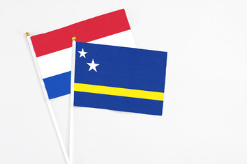 Curacao and Paraguay stick flags on white background. High quality fabric, miniature national flag. Peaceful global concept.White floor for copy space.