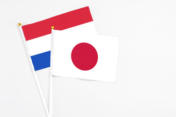 Japan and Paraguay stick flags on white background. High quality fabric, miniature national flag. Peaceful global concept.White floor for copy space.