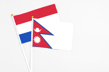 Nepal and Paraguay stick flags on white background. High quality fabric, miniature national flag. Peaceful global concept.White floor for copy space.