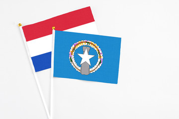 Northern Mariana Islands and Paraguay stick flags on white background. High quality fabric, miniature national flag. Peaceful global concept.White floor for copy space.