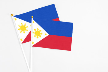 Philippines and Philippines stick flags on white background. High quality fabric, miniature national flag. Peaceful global concept.White floor for copy space.