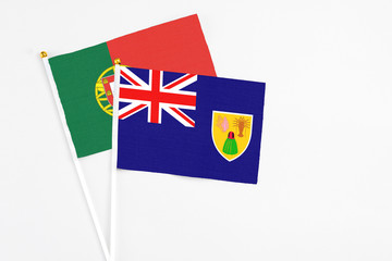 Turks And Caicos Islands and Portugal stick flags on white background. High quality fabric, miniature national flag. Peaceful global concept.White floor for copy space.